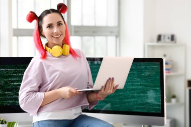 Ofiste dizüstü bilgisayarla çalışan kadın programcı