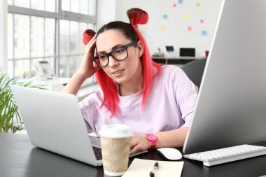 Ofiste dizüstü bilgisayarla çalışan kadın programcı