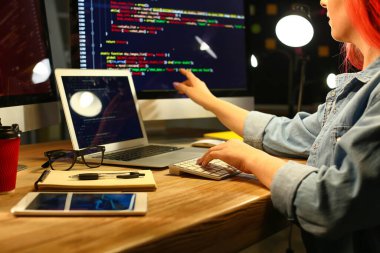 Geceleri ofiste çalışan kadın programcı.