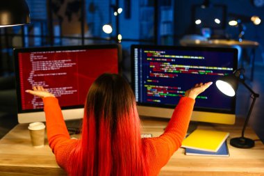 Geceleri bilgisayarla çalışan kadın programcı.