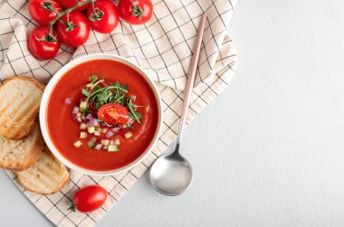 Lezzetli gazpacho ve hafif arka planda dilimlenmiş ekmek kasesi.