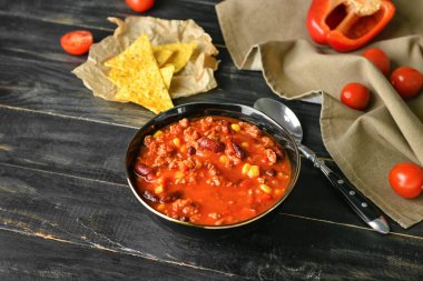 Koyu ahşap arka planda lezzetli kırmızı biberli kase.