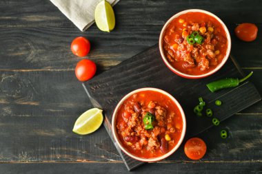 Koyu ahşap arka planda lezzetli biberli kaseler.
