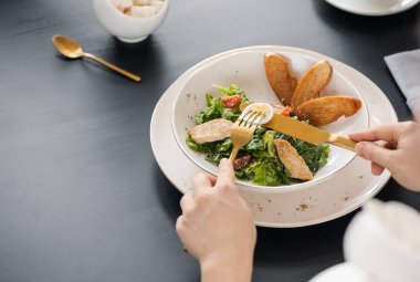 Restoranda Sezar salatası yiyen kadın, yakın plan.