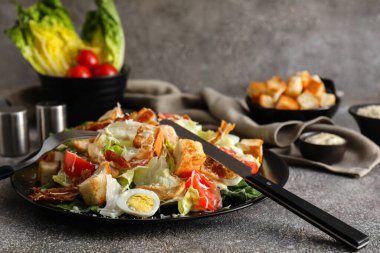 Arka planda lezzetli Sezar salatası tabağı, yakın plan.