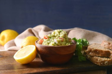 Lezzetli guacamole, limon ve ekmek dilimli bir kase.