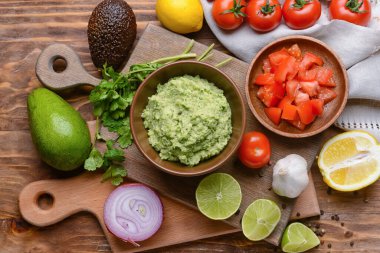Lezzetli guacamole ve ahşap arka planda sebzeli kompozisyon