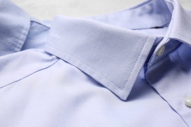 Açık arkaplanda şık erkek gömlekleri, yakın plan.