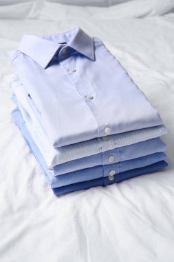 Kumaş arka planda şık erkek gömlekleri yığını