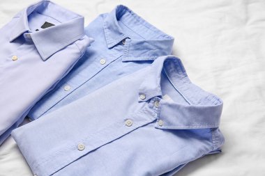 Kumaş arka planda şık erkek gömlekleri, yakın plan.