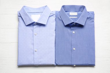 Hafif ahşap arka planda şık erkek gömlekleri