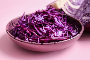 Renkli arka planda kesilmiş taze mor lahanalı kase, yakın plan