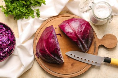 Açık arkaplanda taze mor lahana parçaları olan tahta