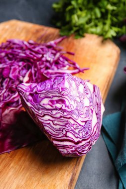 Kesik mor lahanalı tahta koyu arka planda, yakın plan.