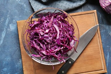 Renkli arka planda kesilmiş taze mor lahanalı kase, yakın plan