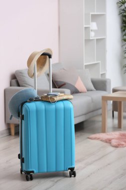 Packed suitcase with immune passport, medical mask and travel accessories in room