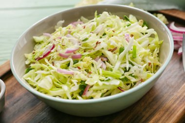 Bowl with tasty cabbage salad on table