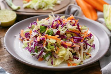 Ahşap masada lezzetli lahana salatası tabağı, yakın plan.