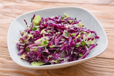 Ahşap masada lezzetli lahana salatası tabağı, yakın plan.