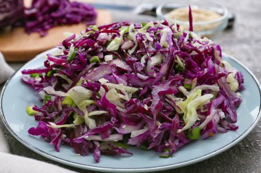 Arkaplanda lezzetli lahana salatası tabağı, yakın plan.