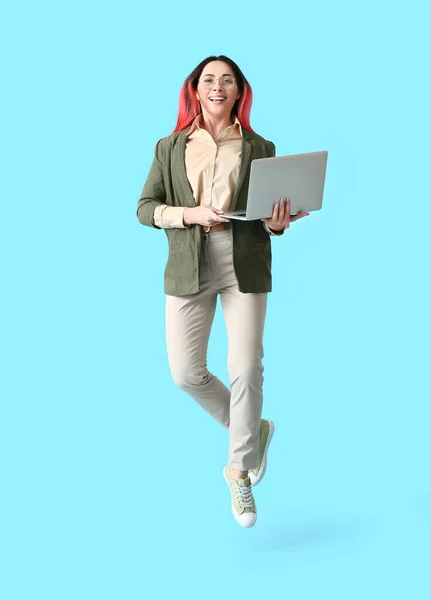 Programmiererin Mit Laptop Springt Auf Farbigem Hintergrund — Stockfoto