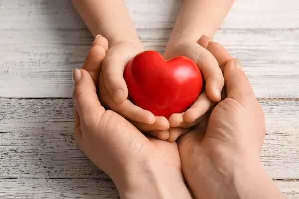 Mani Donna Bambino Con Cuore Rosso Sfondo Legno Chiaro Primo — Foto Stock