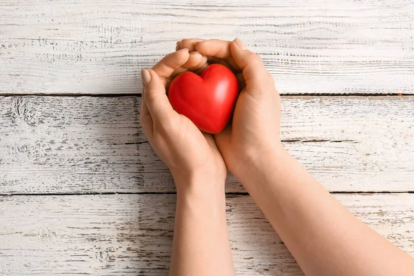 Vrouwelijke Handen Met Rood Hart Lichte Houten Achtergrond — Stockfoto