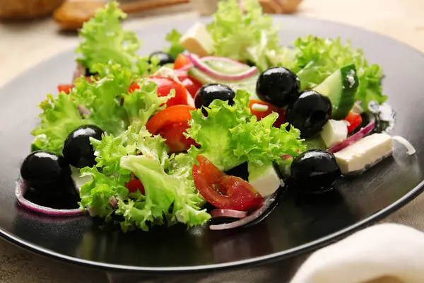 テーブルの上においしいギリシャのサラダとプレート クローズアップ — ストック写真
