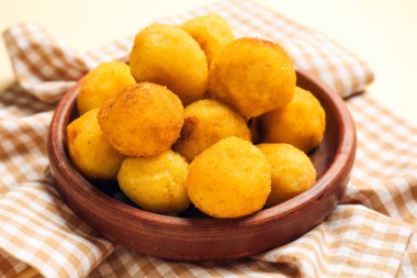 Plate with fried potato balls on napkin