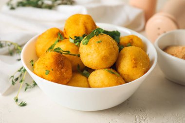 Hafif arka planda kızarmış patates topları olan bir kase.