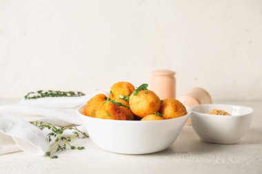 Bowl with tasty fried potato balls on table