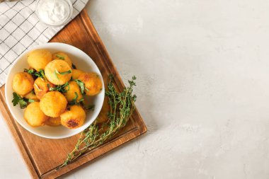 Hafif arka planda kızarmış patates topları olan bir kase.