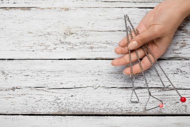 Hafif ahşap arka planda konuşma düzeltmesi için logopedik araçlara sahip bir kadın