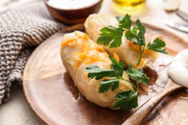 Hafif arka planda içi doldurulmuş lahana dürümlü tabak.