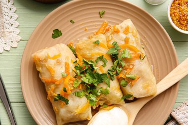 Renkli ahşap arka planda lezzetli lahana rulosu tabağı.