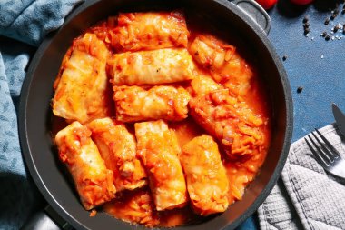 Renkli arkaplanda lezzetli lahana sarmalarıyla kızartma tavası