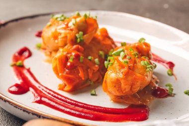 Koyu arkaplanda lezzetli lahana ruloları olan tabak.