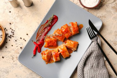 Hafif arka planda içi doldurulmuş lahana dürümlü tabak.