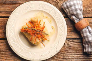 Ahşap arka planda lezzetli lahana ruloları olan tabak.