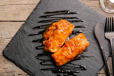 Ahşap arka planda lezzetli lahana ruloları olan tabak.