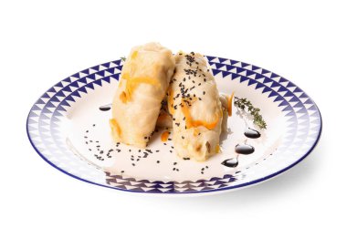 Beyaz arka planda lezzetli lahana sarmaları olan tabaklar.