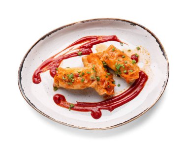 Beyaz arka planda lezzetli lahana sarmaları olan tabaklar.