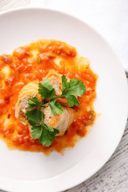 Hafif arka planda içi doldurulmuş lahana dürümlü tabak, yakın plan.