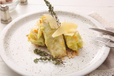 Hafif ahşap arka planda içi doldurulmuş lahanalı tabaklar, yakın plan.