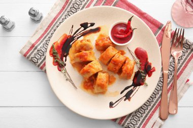 Hafif ahşap arka planda içi doldurulmuş lahana ruloları olan bir tabak.