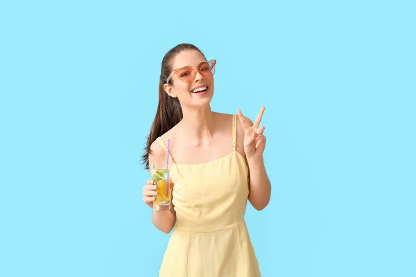 Mladá Žena Čerstvou Limonádou Ukazující Vítězství Gesto Barevném Pozadí — Stock fotografie