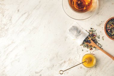 Arka planda kuru yapraklı çay poşeti ve kaşık