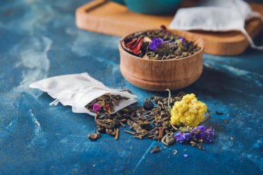 Renkli yapraklı çay poşeti ve kase