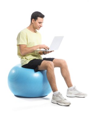 Beyaz arka planda fitbol ve dizüstü bilgisayarı olan sportif erkek antrenör