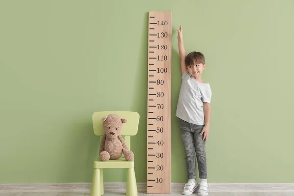 Маленький Мальчик Измеряет Высоту Рядом Цветной Стеной — стоковое фото